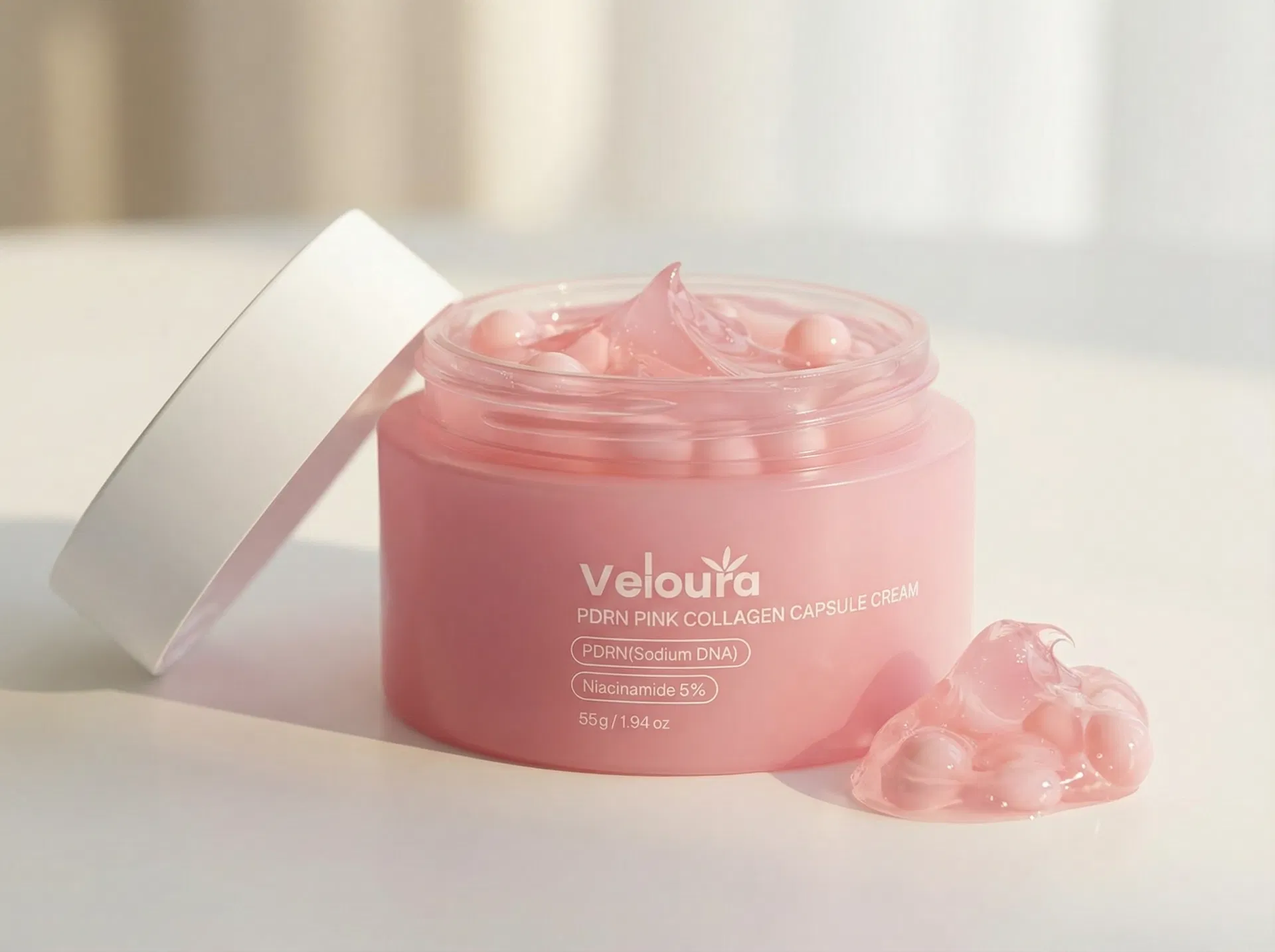 Close-up of pink PDRN capsules being scooped from the cream jar