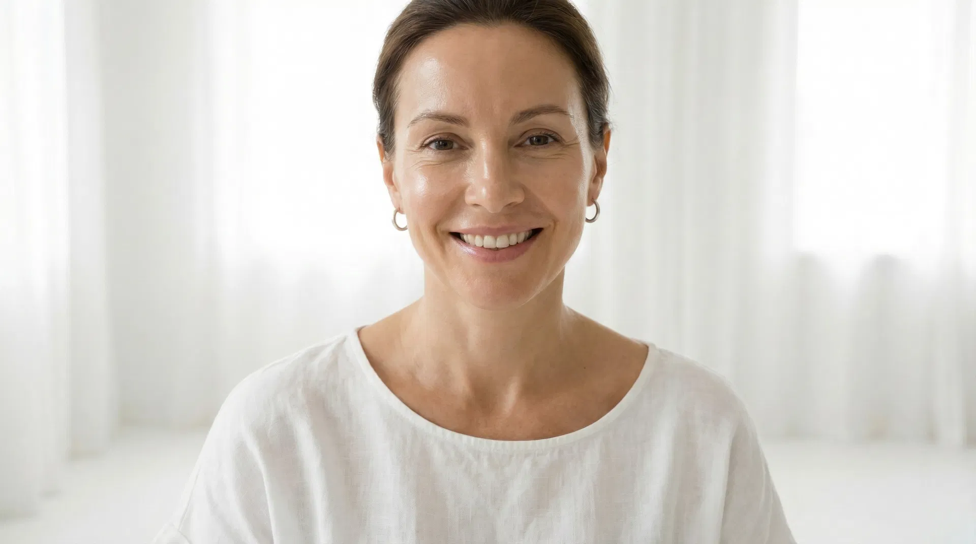 Confident woman with radiant, glowing skin — the results of red light therapy at Lume Light Wellness