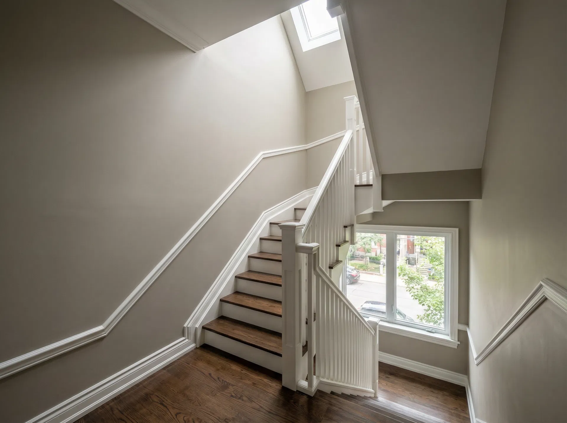 Full home repaint - beautifully painted staircase with warm greige walls and crisp white trim