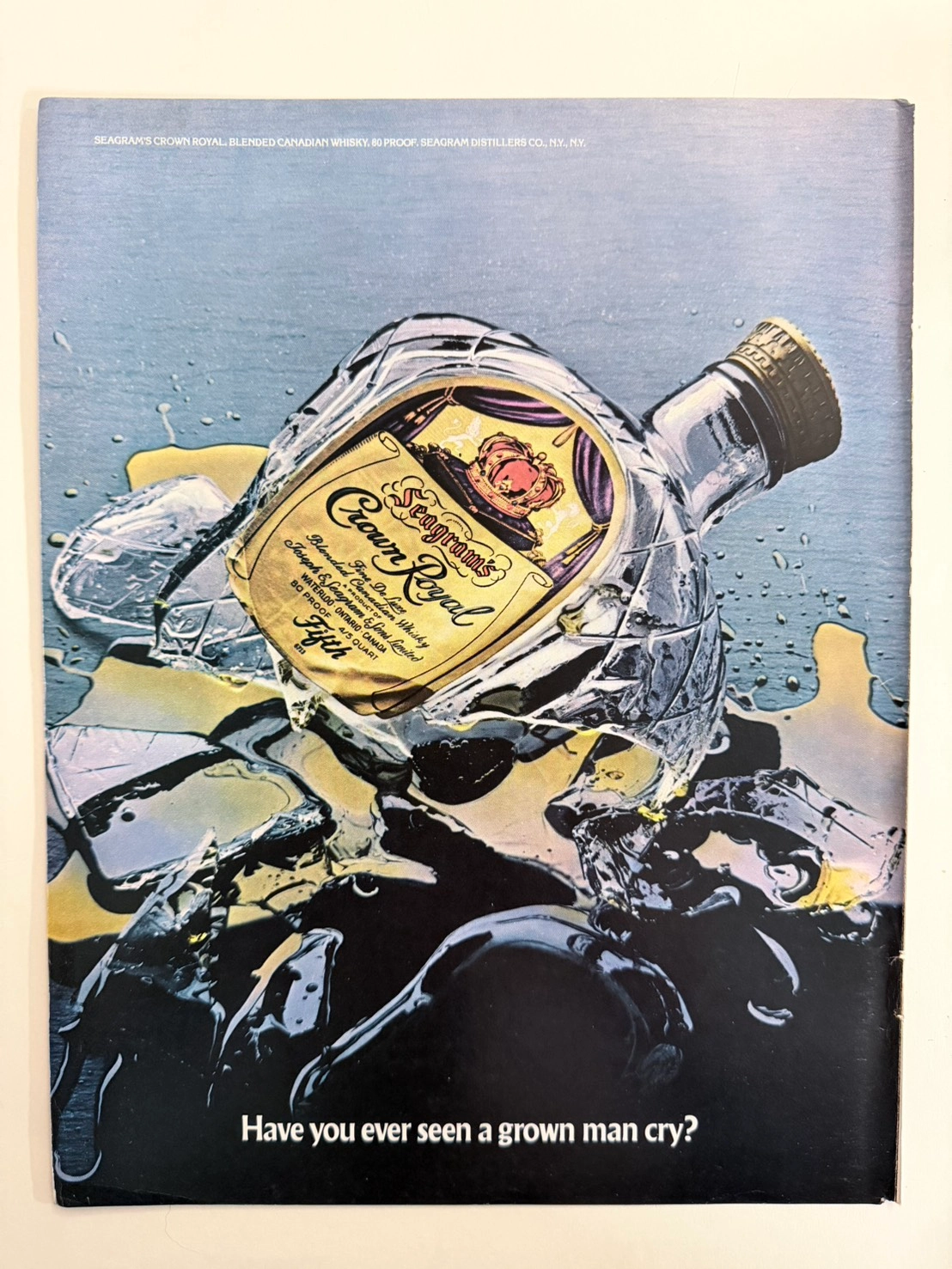 Original 1970s vintage print advertisement for Crown Royal featuring a shattered bottle and the text "Have you ever seen a grown man cry?"
