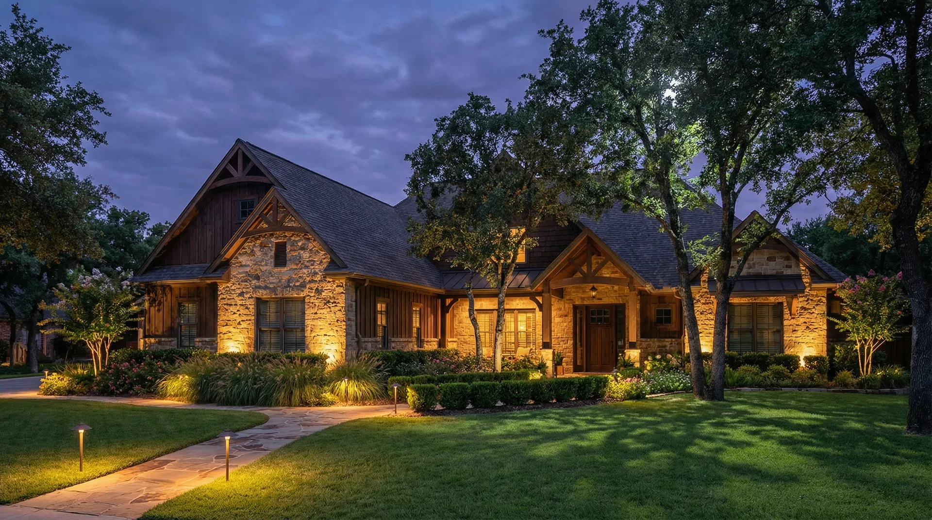 Craftsman home with uplighting and landscape path lights at twilight in Norman Oklahoma