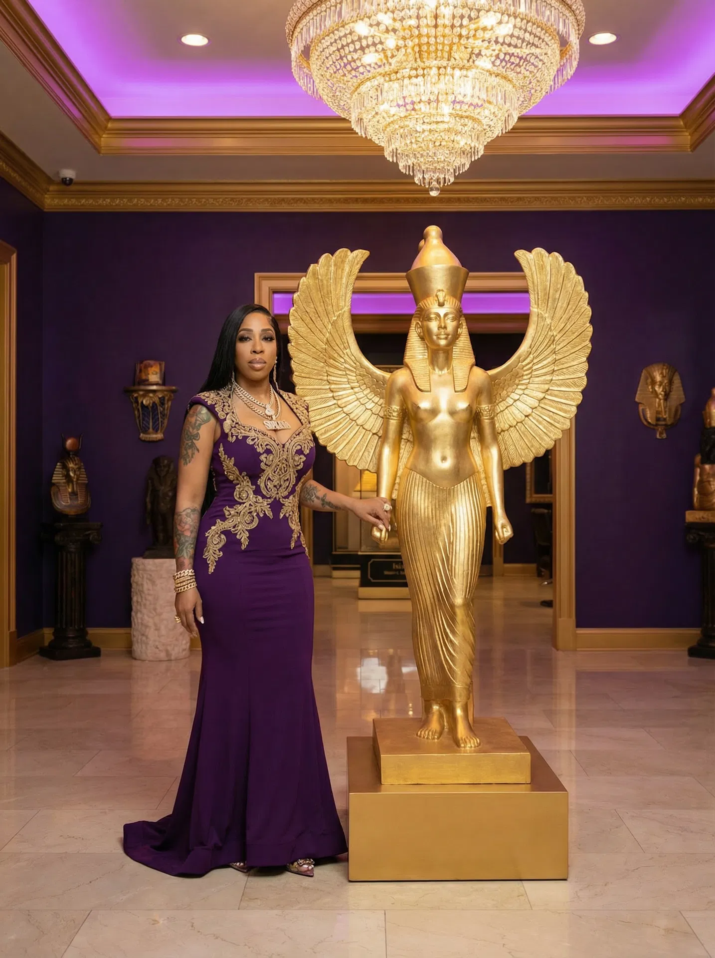 Dr. Saacha Spade — Founder of Isis Beauty Bar, standing next to a golden Isis goddess statue