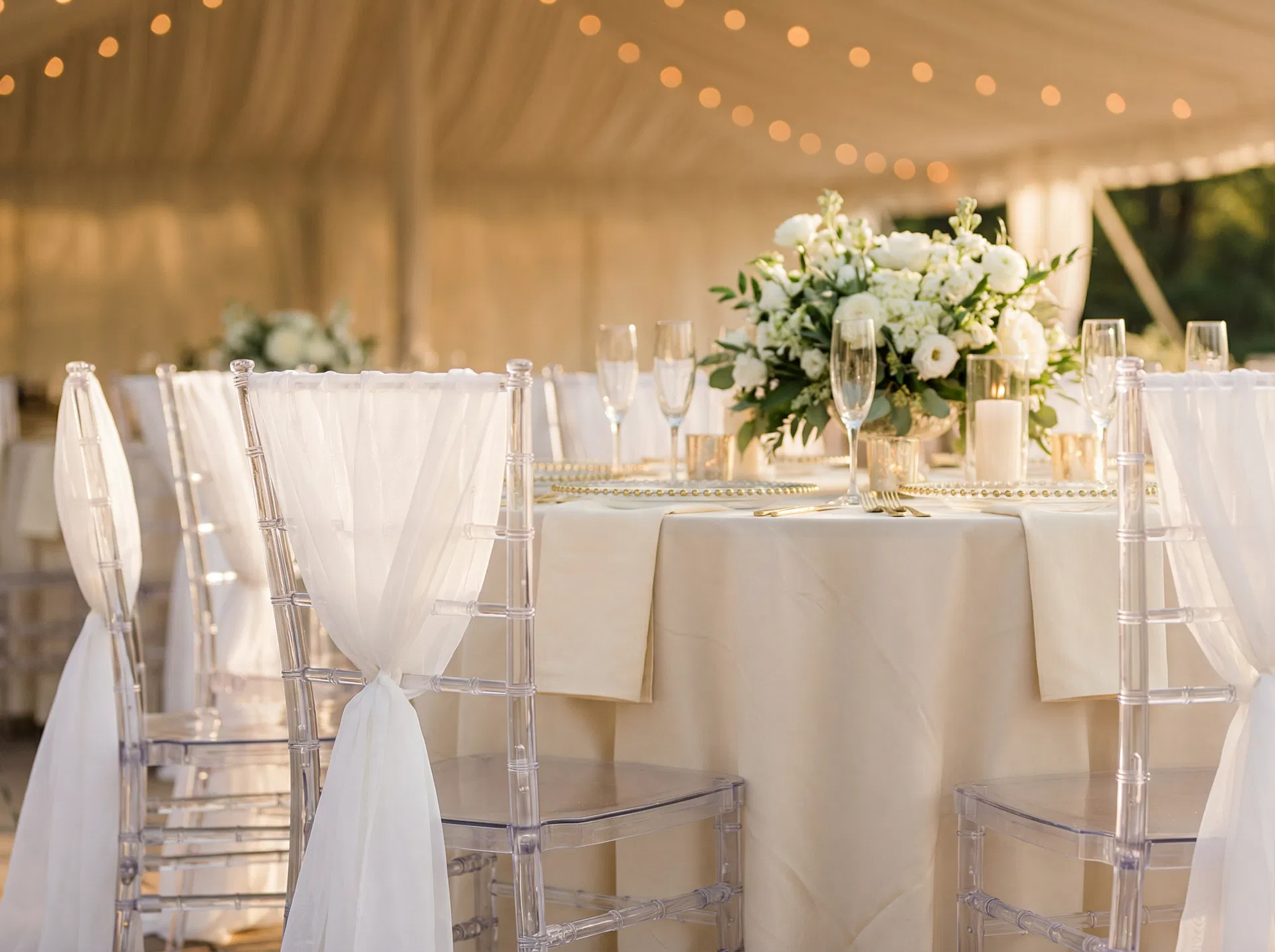 Ghost chiavari chairs at a Utah wedding reception with white floral centerpieces