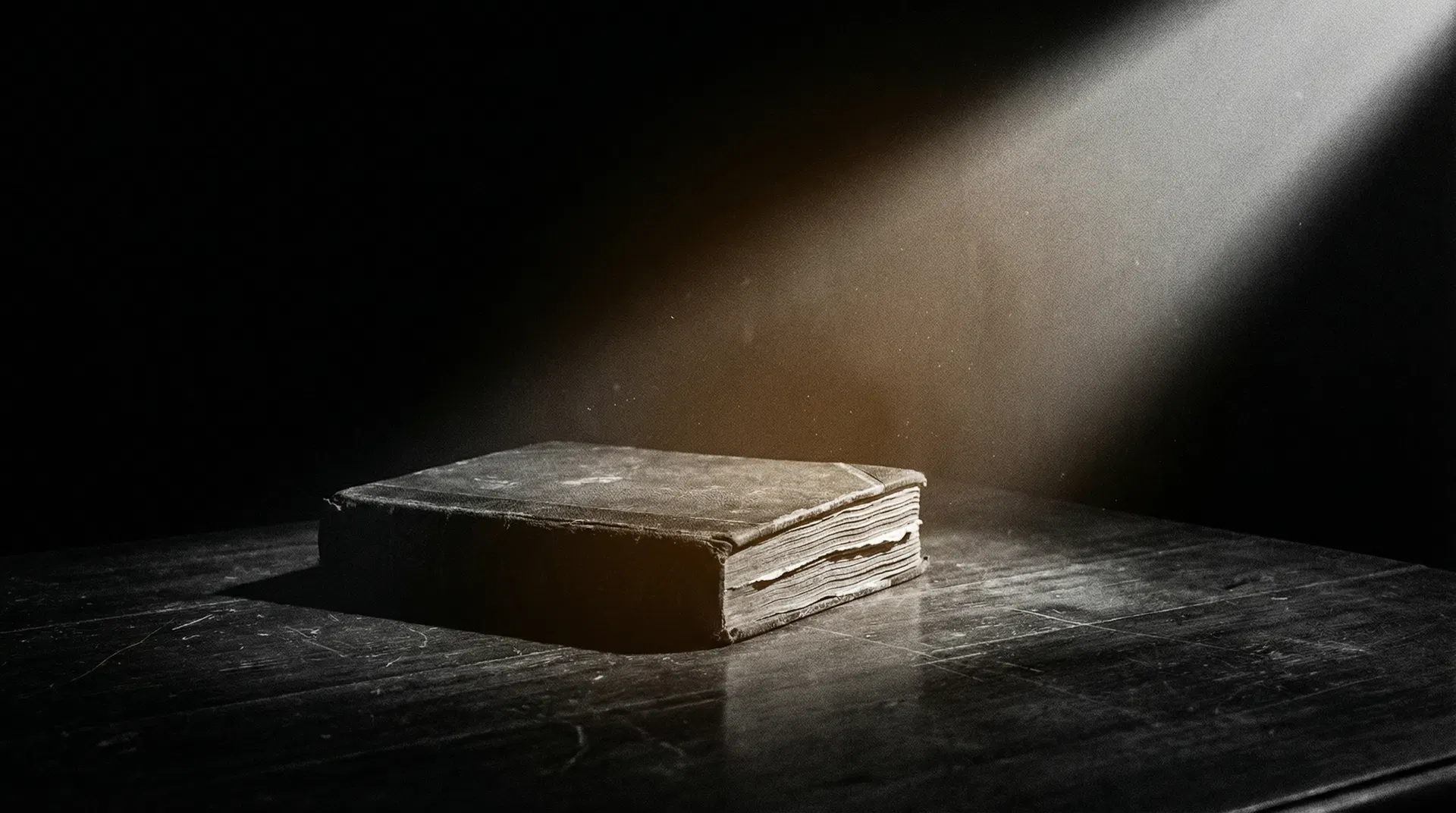 Livro antigo sob feixe de luz representando conhecimento e revelação