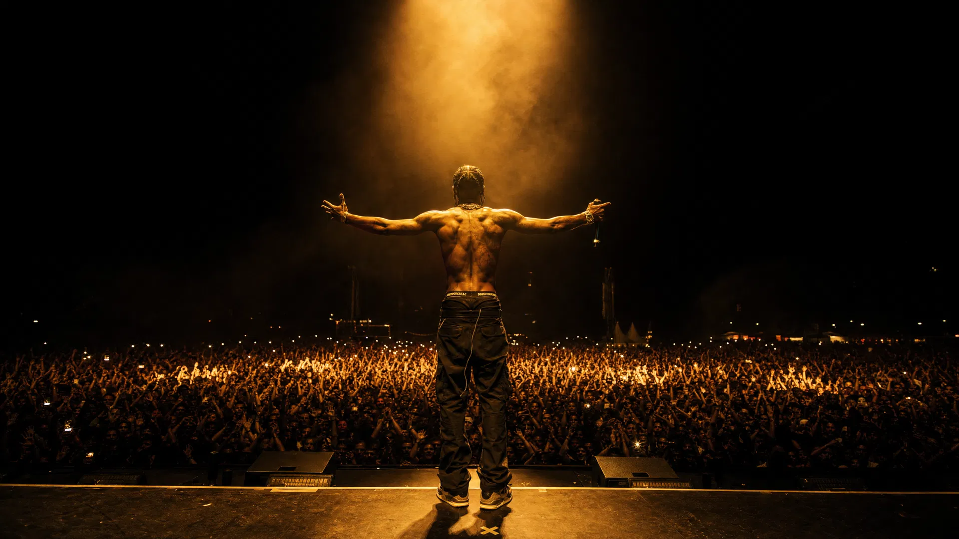 DMX performing live, arms outstretched before a massive crowd