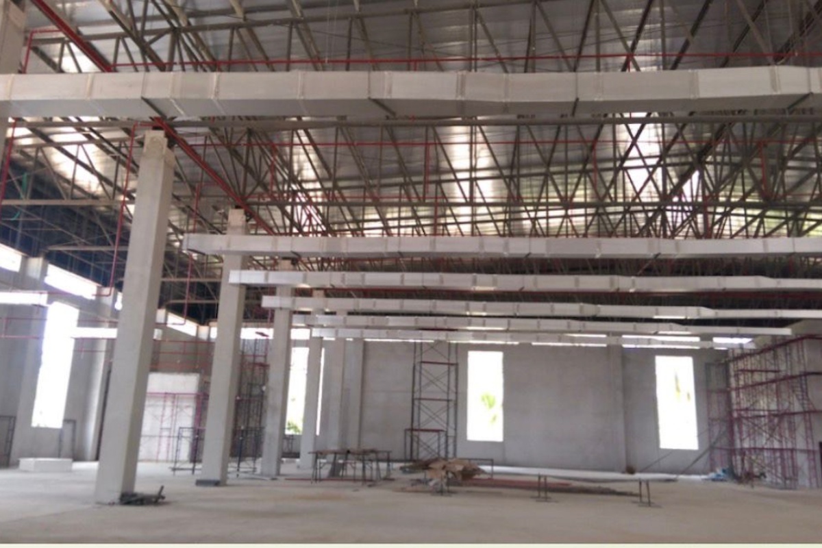 Land for Sale in Nong Pla Lai, interior of a large industrial building under construction with exposed beams and ductwork.