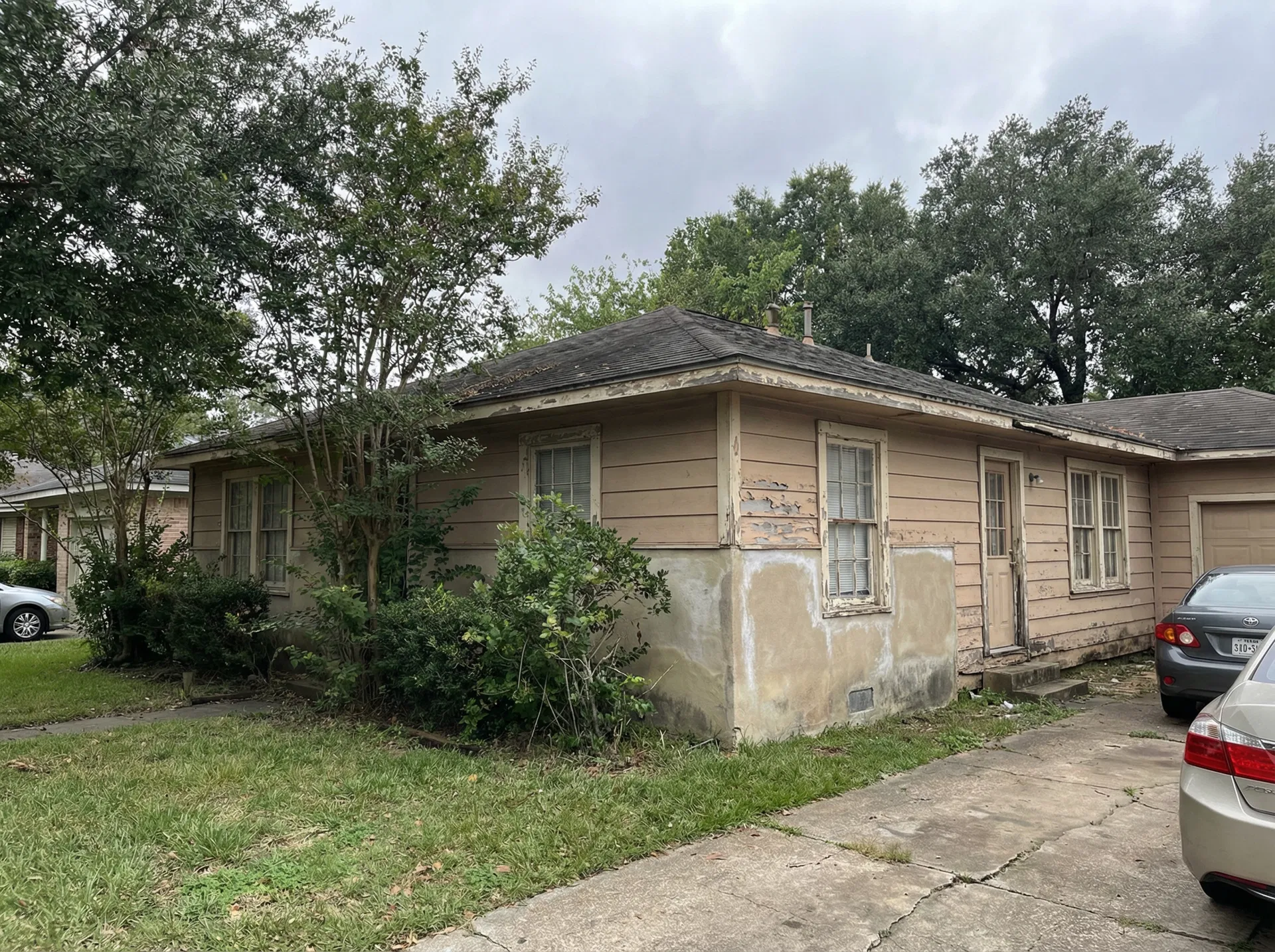 Houston home exterior before painting — faded peeling paint, weathered siding