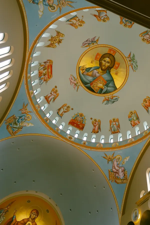 Detailed religious frescoes of Christ, angels, and saints on an Orthodox church dome in Charlotte, NC.