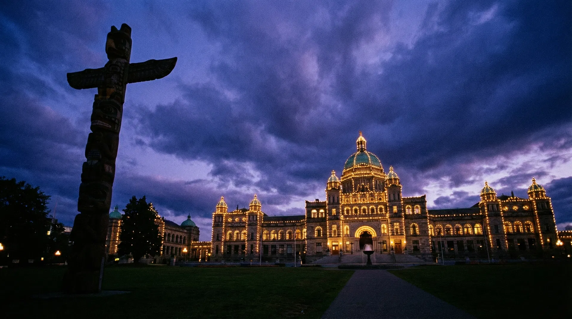 BC Legislature at dusk with totem pole silhouette