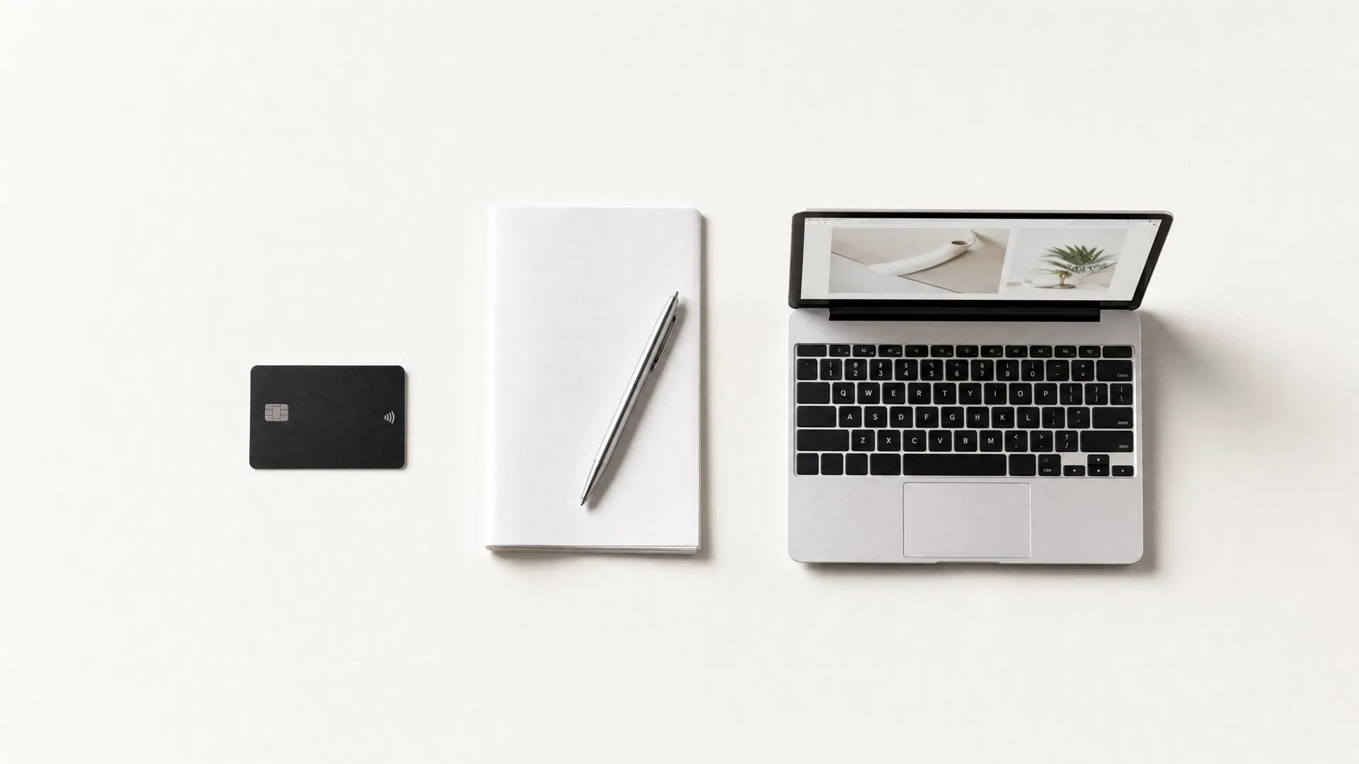 Carte bancaire, formulaire papier et ordinateur portable disposés sur un fond crème