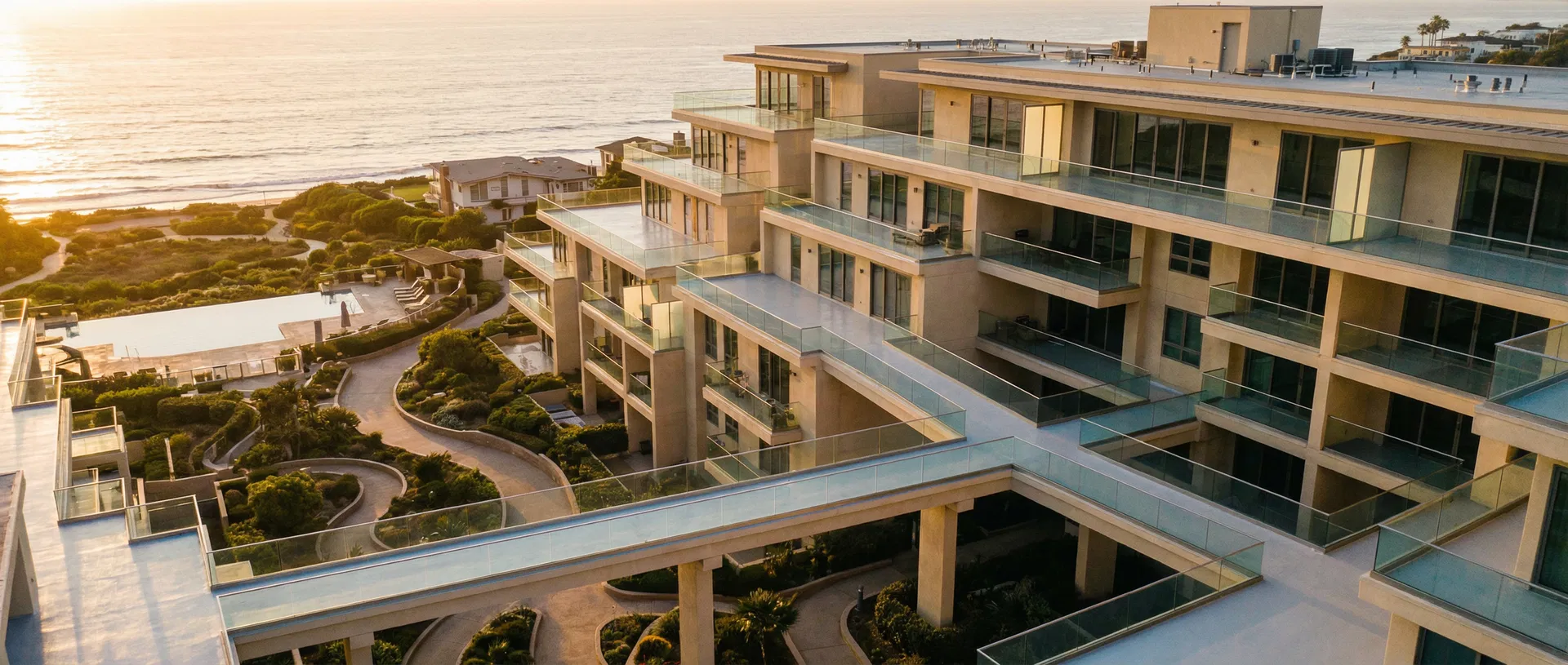 Luxury California apartment complex with balconies overlooking the Pacific Ocean at golden hour