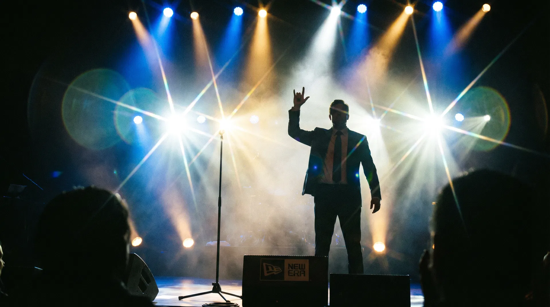 Silhouette of confident man on stage with dramatic spotlights