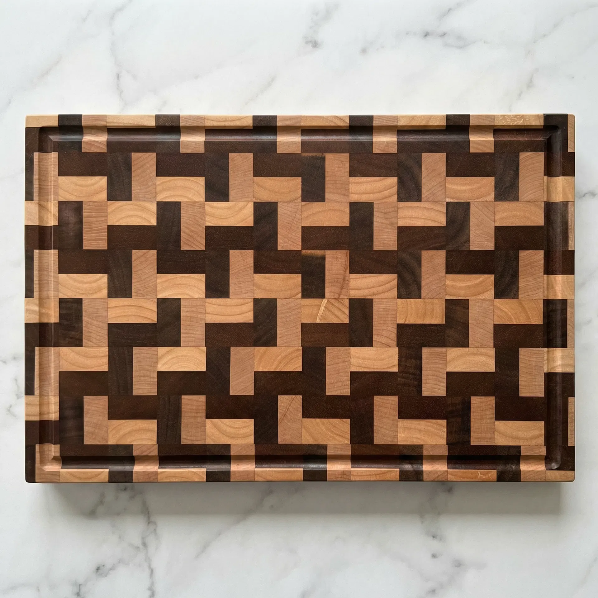 קרש חיתוך end-grain מלמעלה עם ערוץ ניקוז על משטח שיש לבן