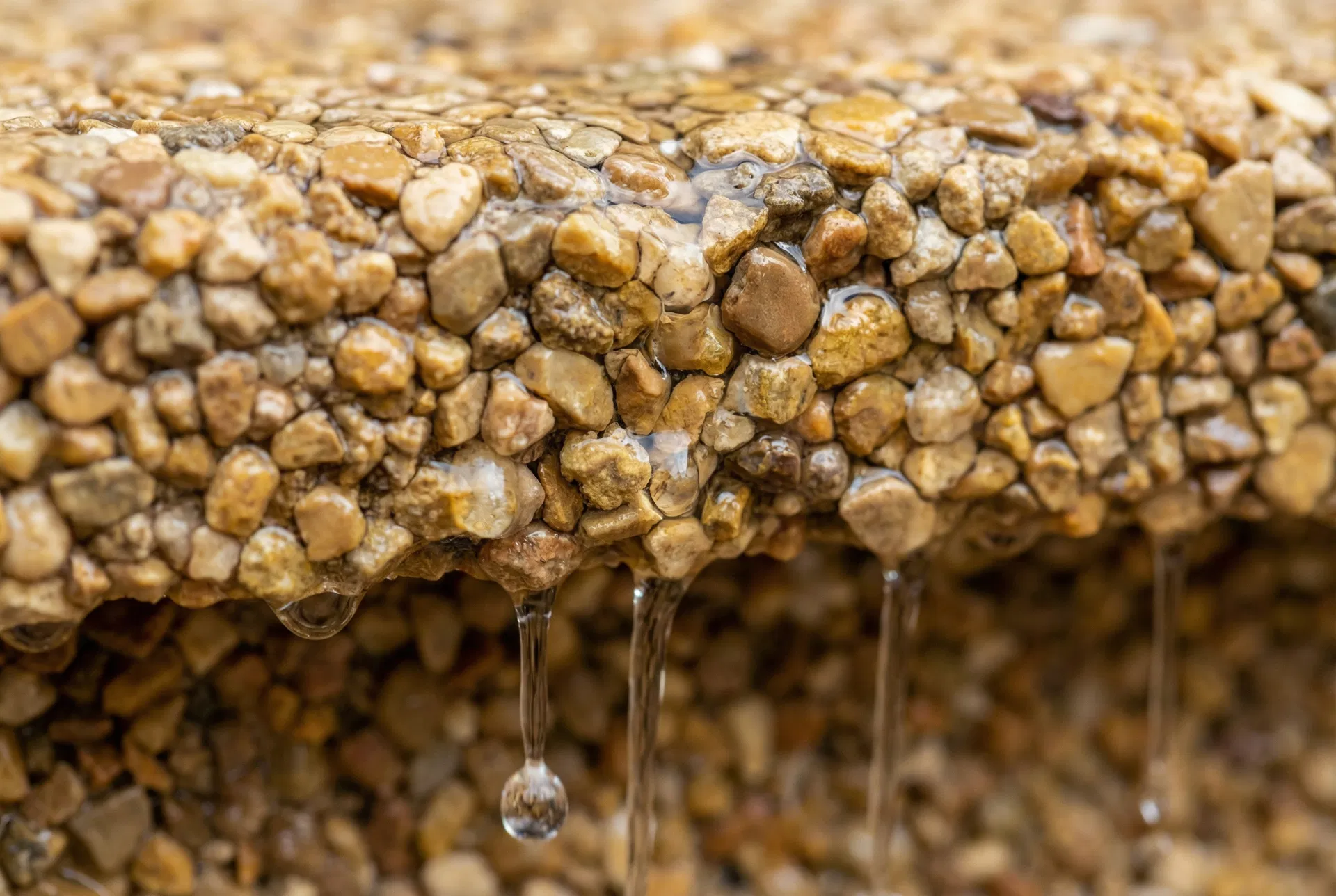Close-up of water draining through permeable resin-bound stone surface