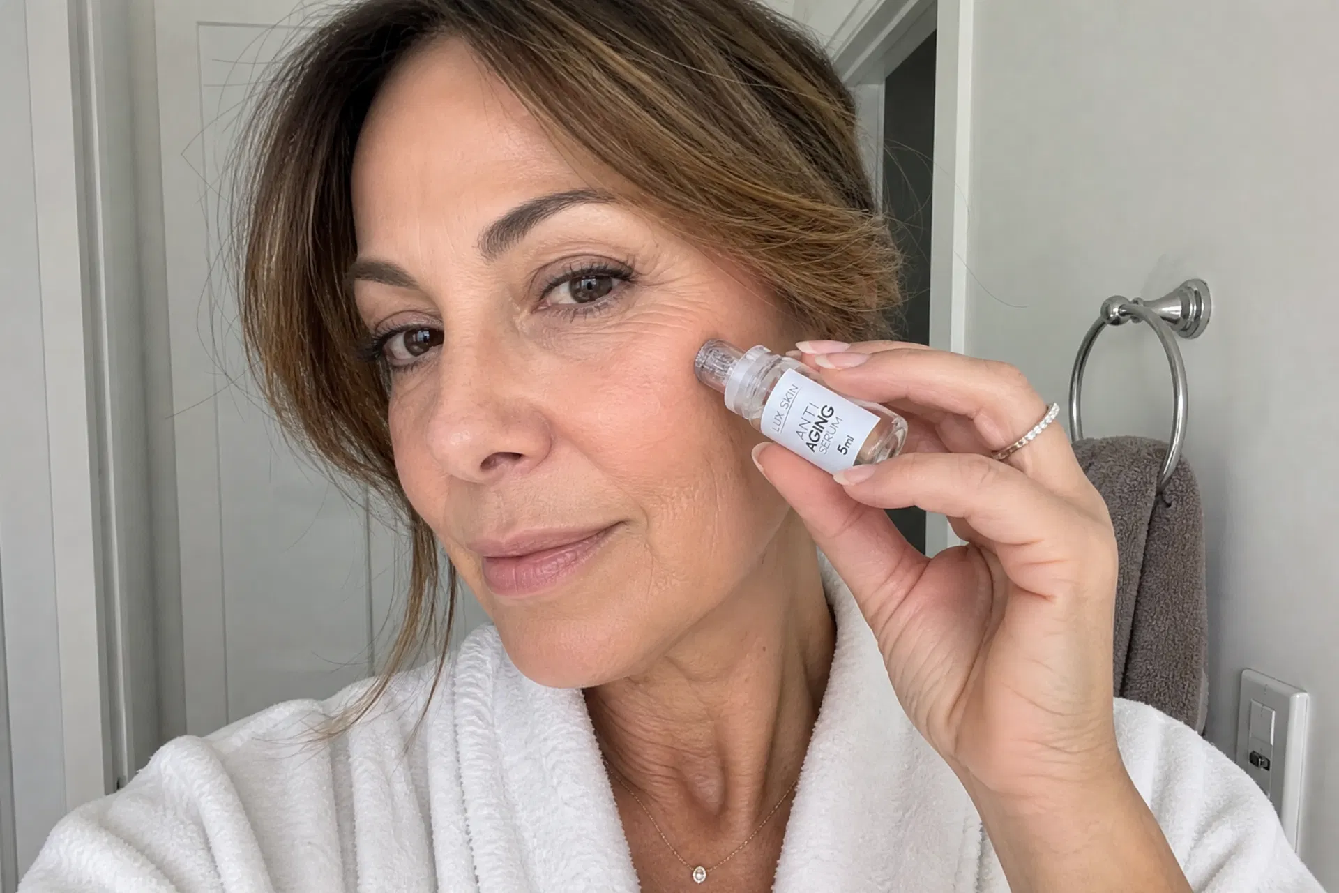 Woman applying LUX SKIN micro-infusion to cheek