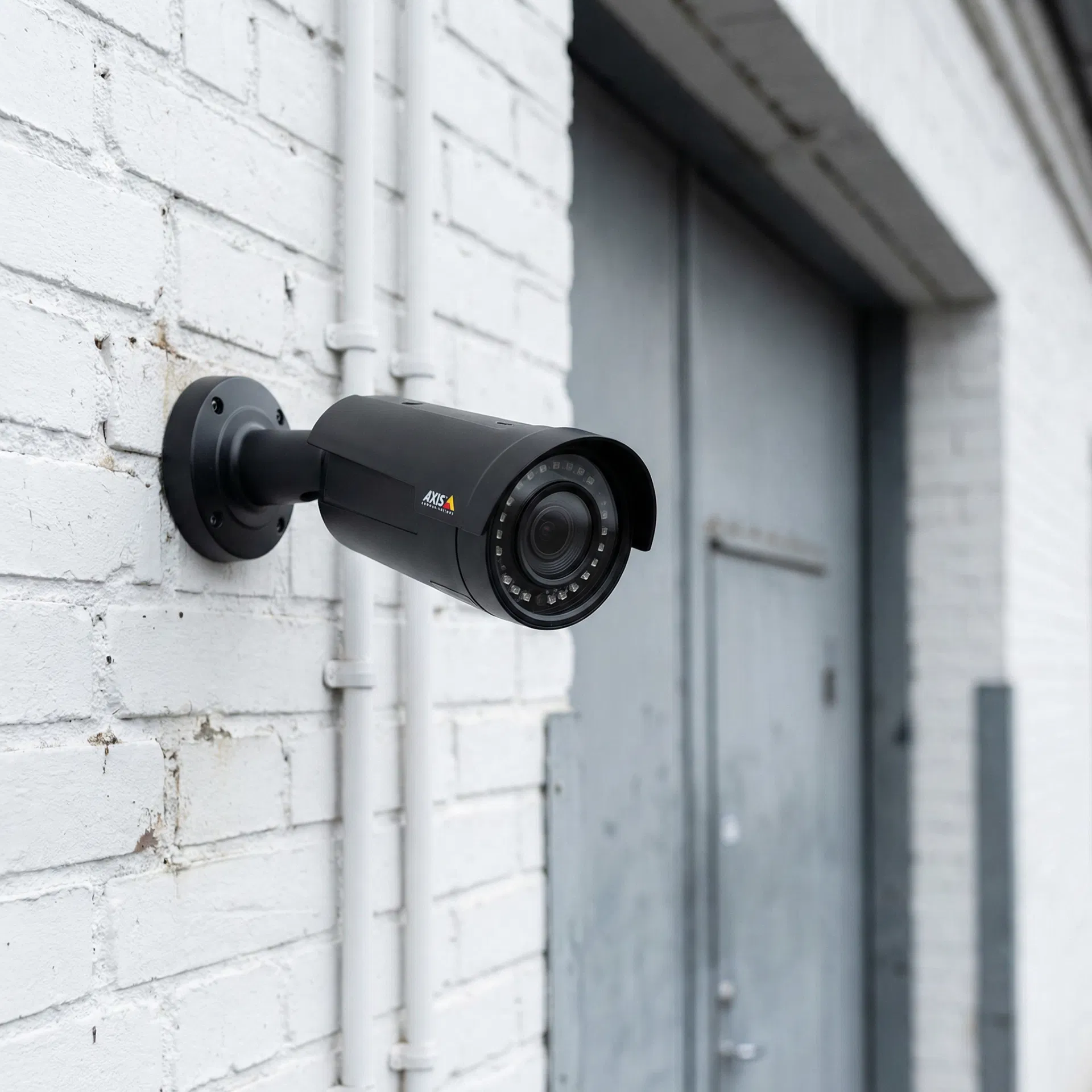 Axis bullet-kamera monteret på hvid murvæg