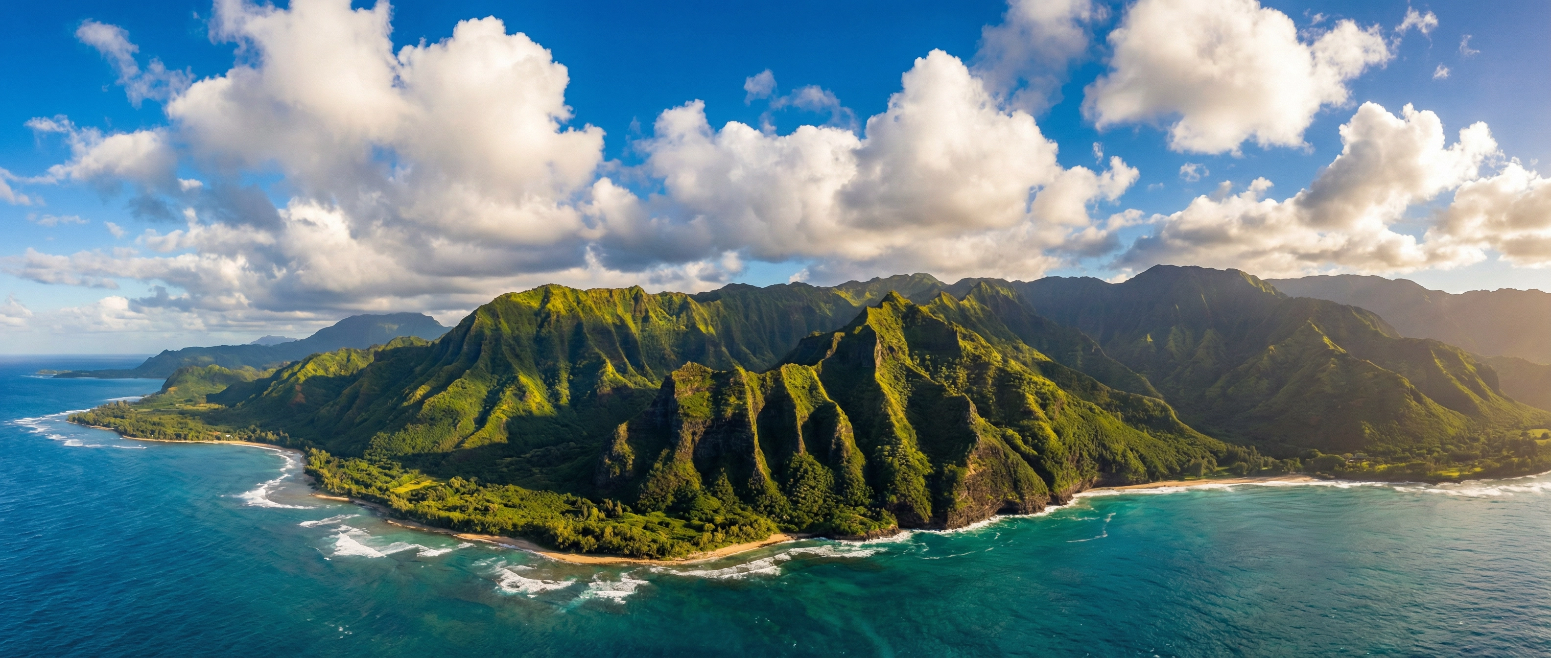 Breathtaking aerial view of Hawaii's lush green mountains meeting the turquoise Pacific Ocean