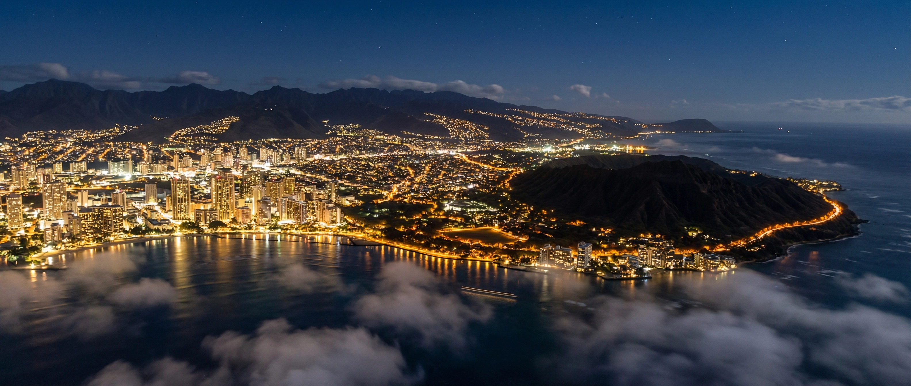Aerial view of O'ahu at night with city lights and coastline