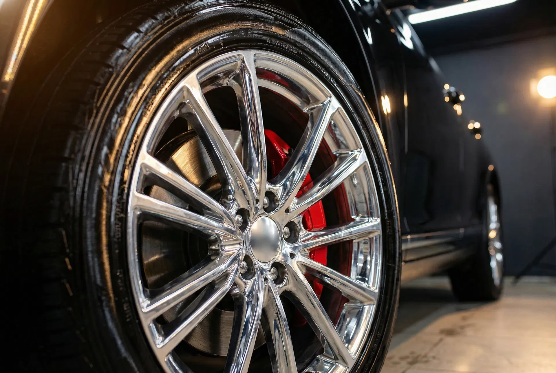 Close-up of freshly detailed chrome wheel with red brake caliper