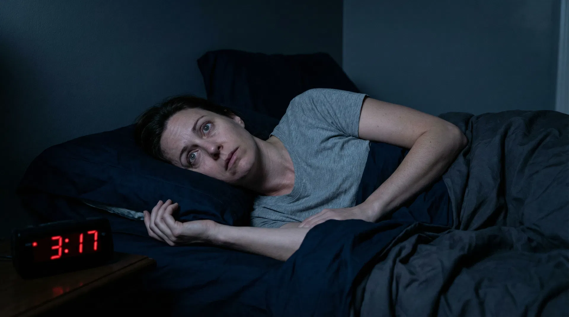 Woman lying awake at 3:17 AM staring at the clock