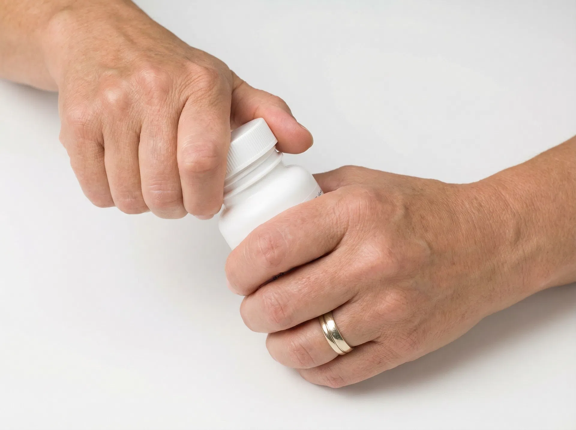 Hands opening a pill bottle confidently