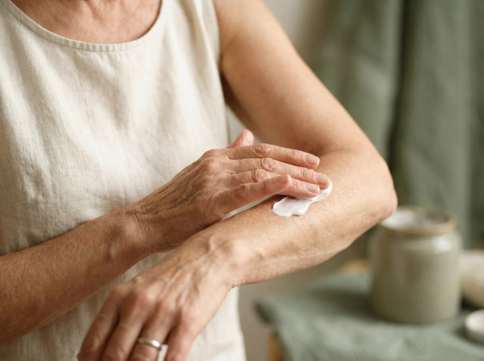 Woman applying cream to her arms