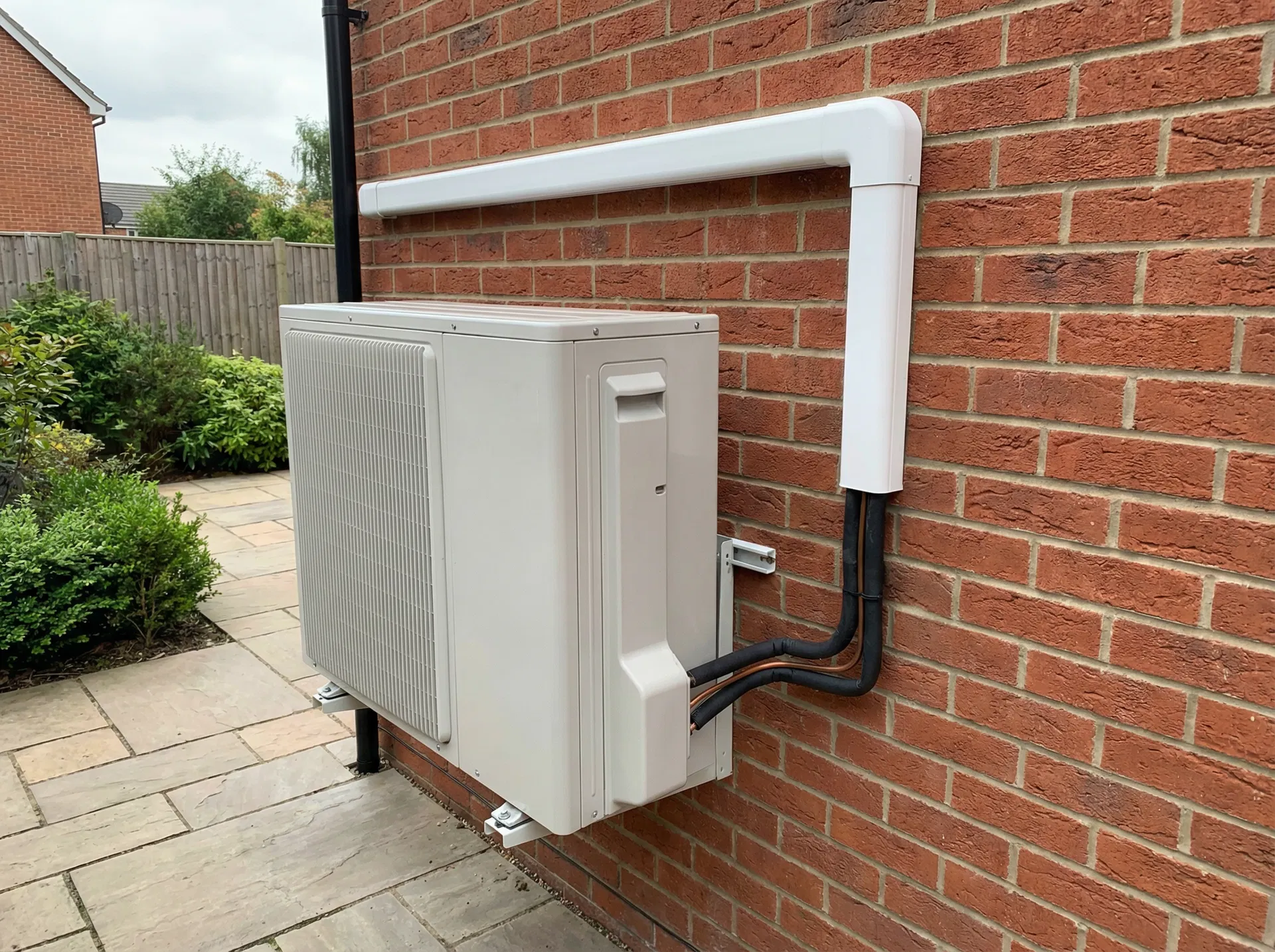 Outdoor condenser unit neatly installed on a British home exterior