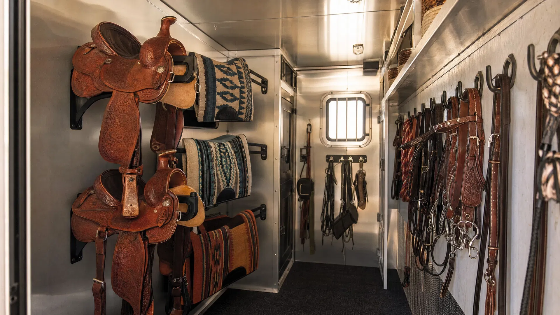 Organized tack room interior with saddle racks and bridle hooks