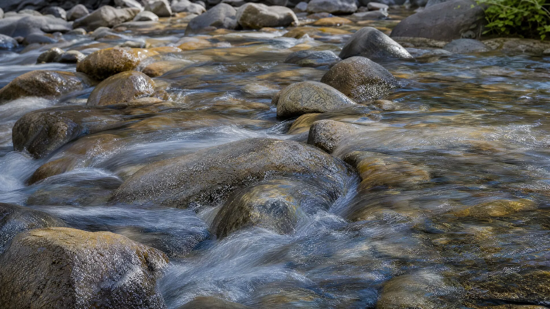 Clear mountain water flowing over mineral-rich stone
