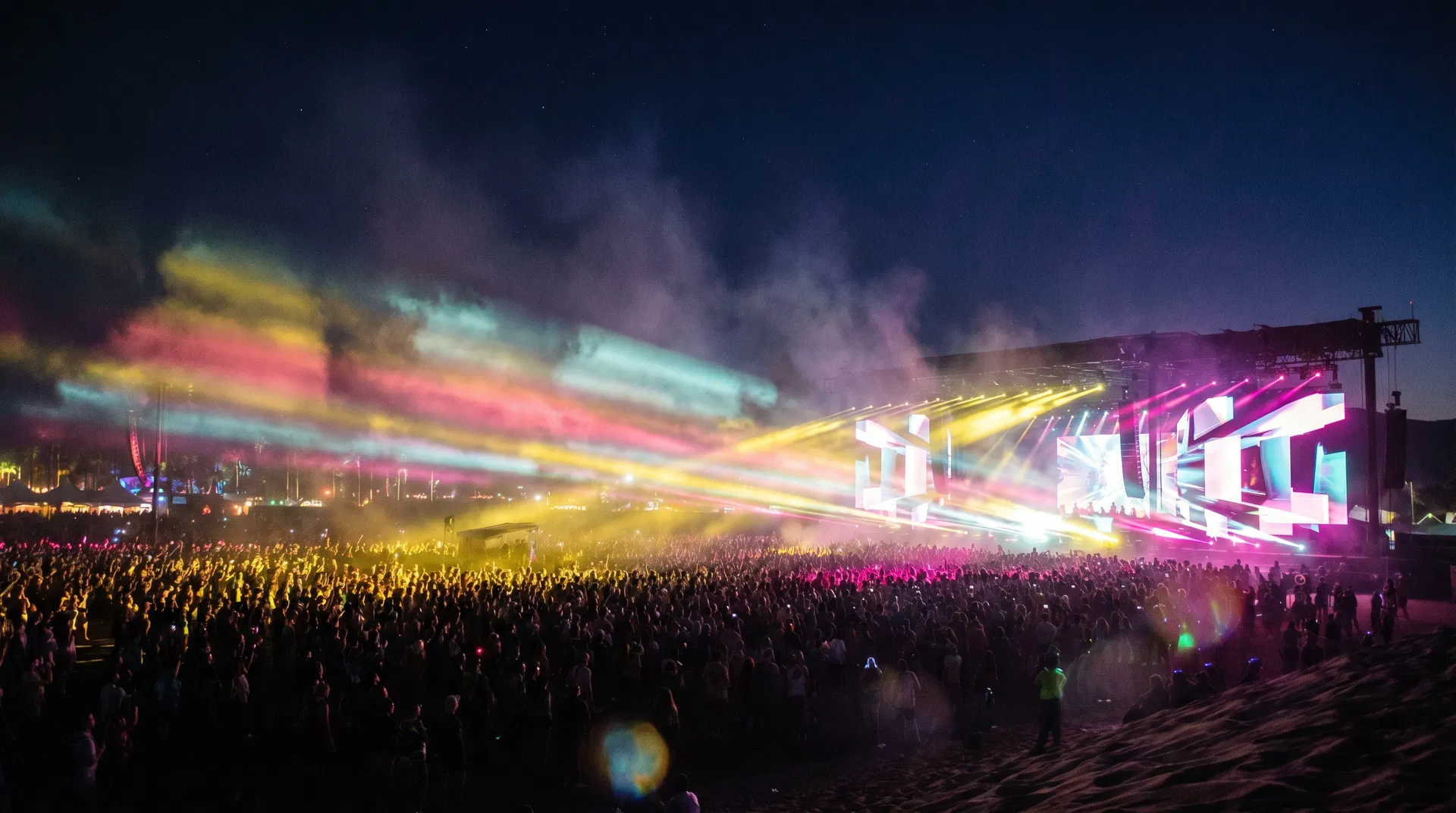Nighttime Coachella concert lights and crowd in the desert