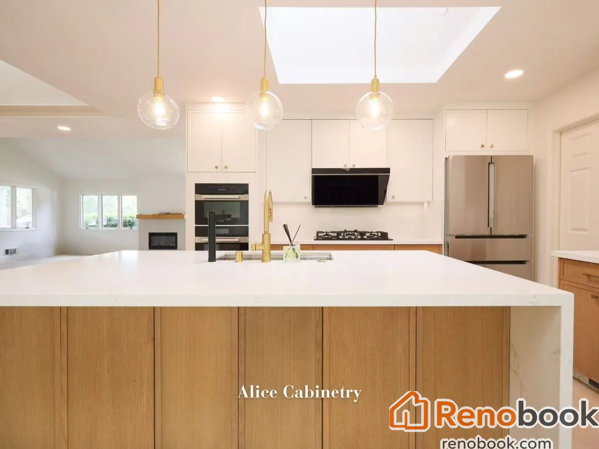 Modern two-tone kitchen with light wood cabinetry, quartz island, and skylights in San Leandro, CA, USA