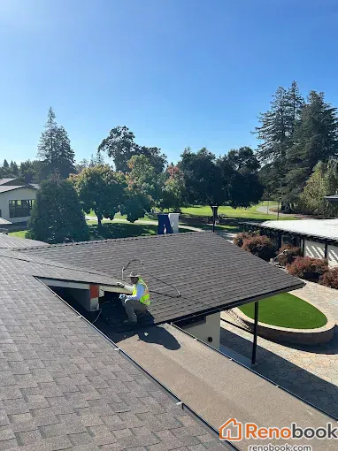 Asphalt shingle roof installation with worker on low-slope section in Menlo Park, CA, USA