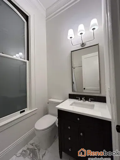 Elegant small bathroom with dark vanity, white quartz top, and marble tile in Menlo Park, CA, USA