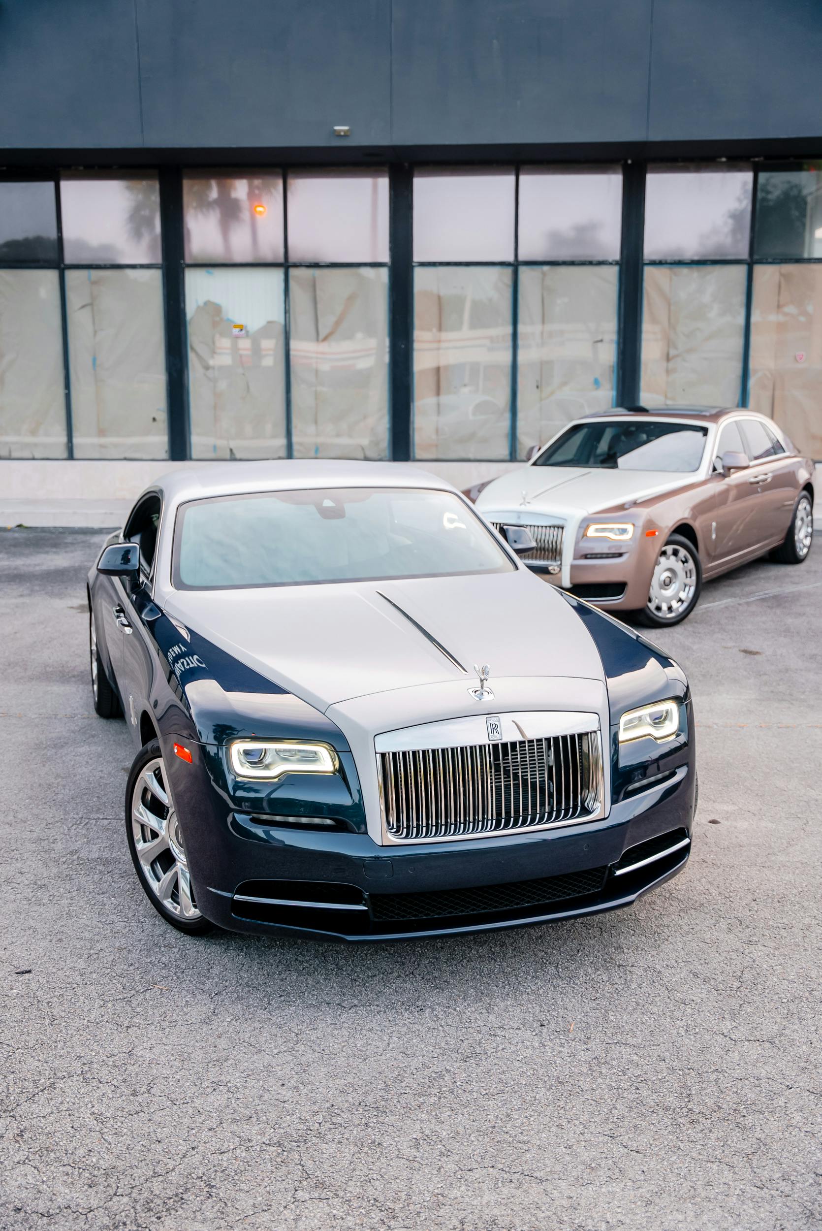 Two Rolls-Royce Luxury Cars Parked by Building