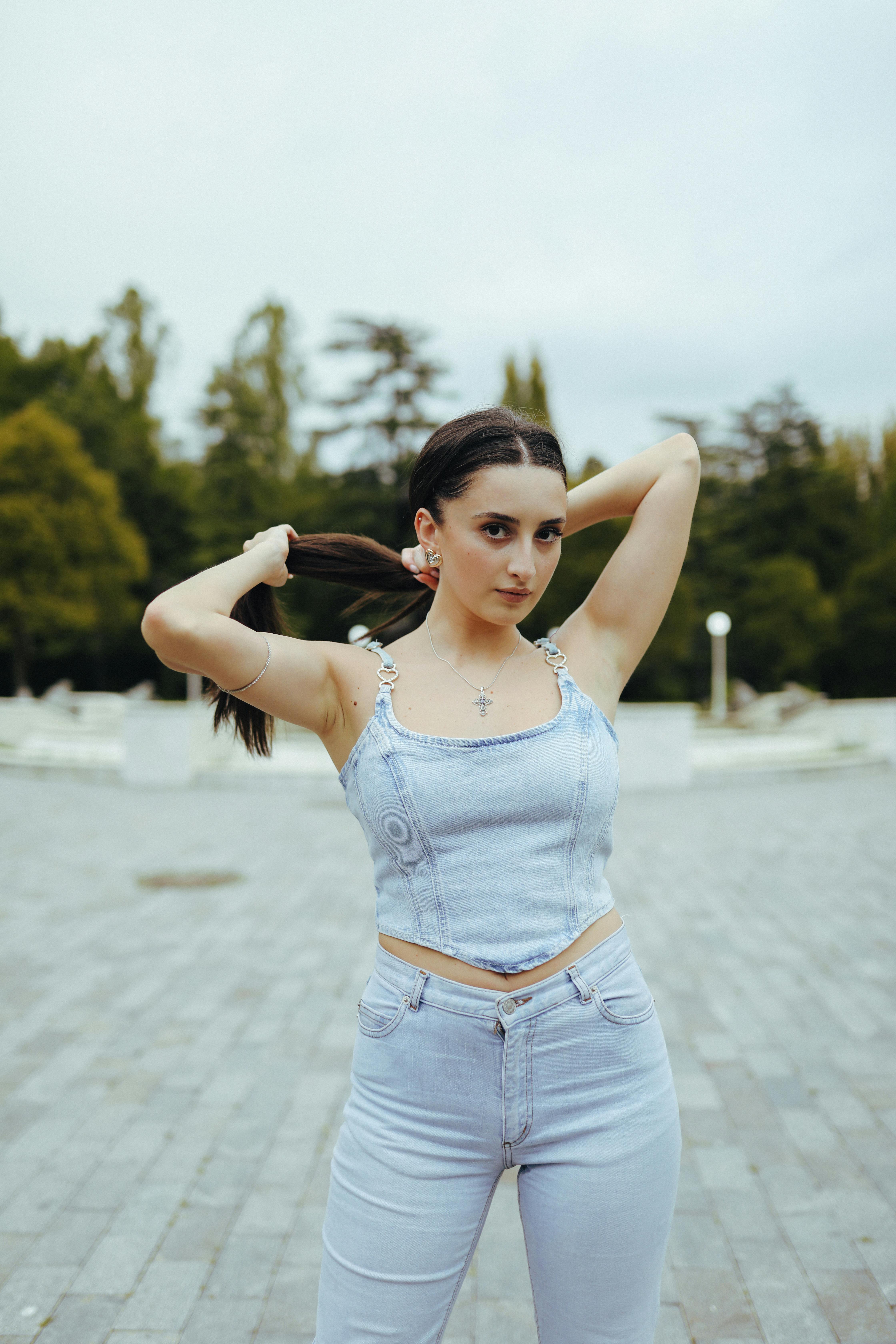 Young Woman Adjusting Ponytail in Urban Park