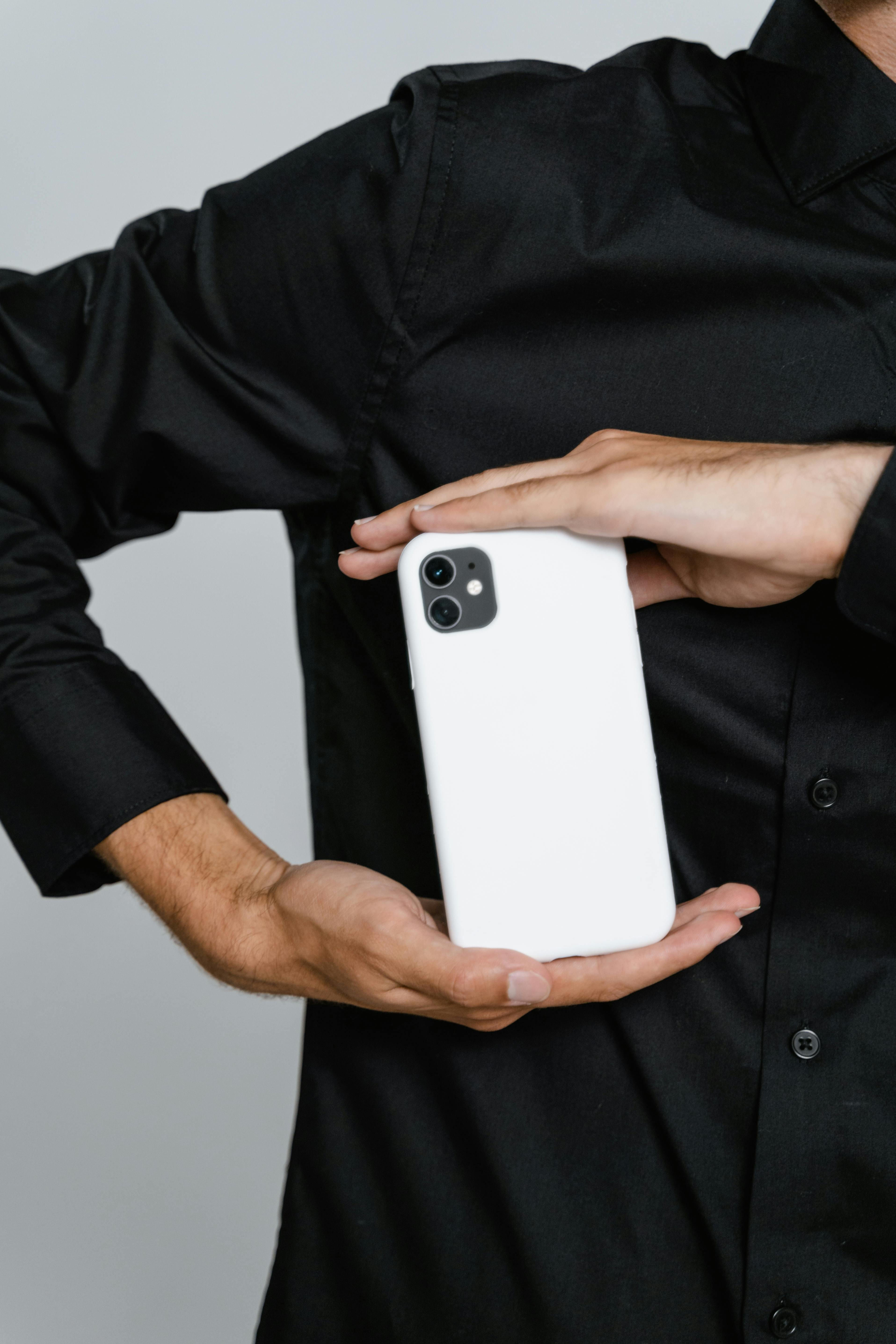Person in black shirt holding white smartphone