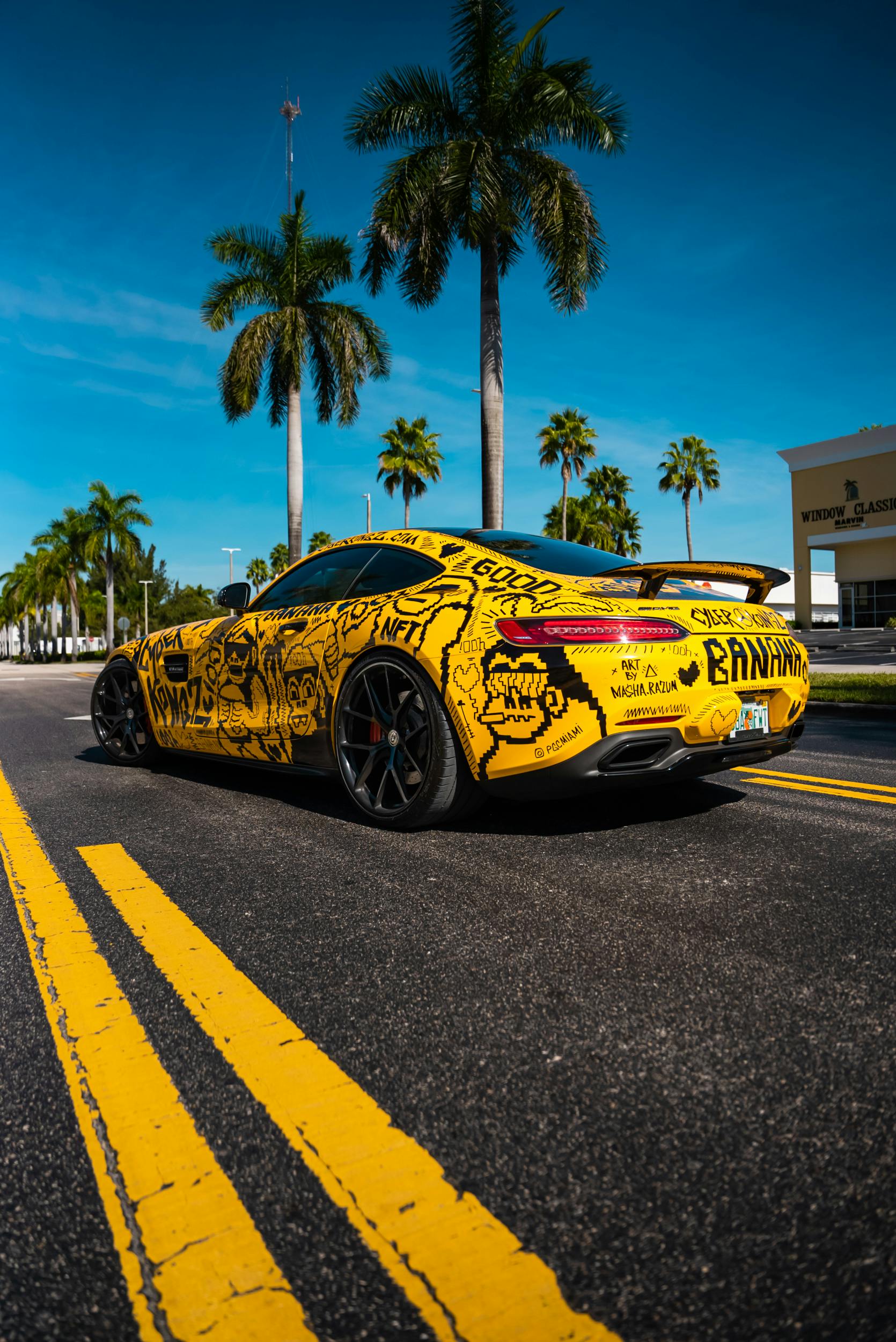 Yellow Graffiti Sports Car on Palm-Lined Street