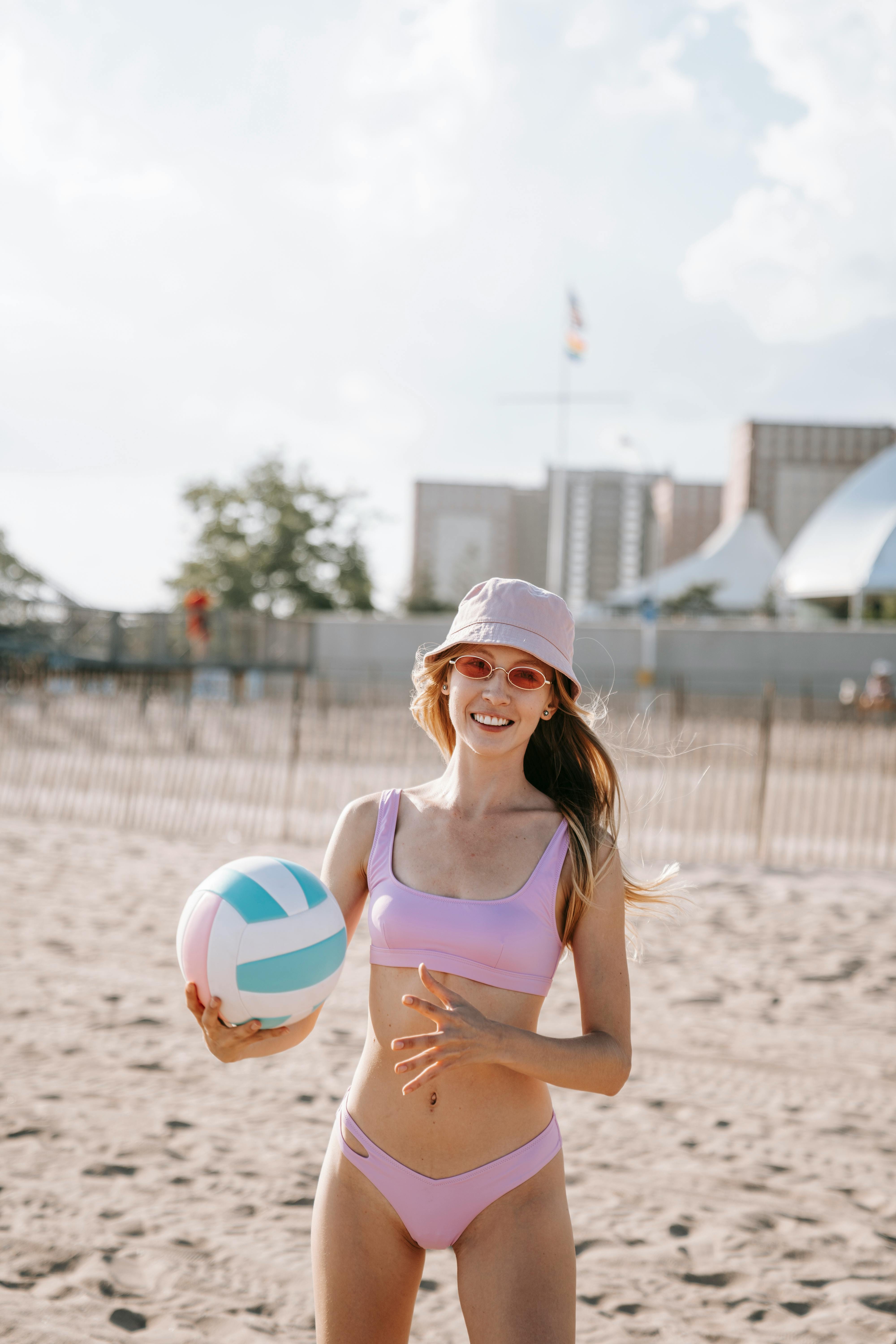 Smiling Young Woman Playing Volleyball on Beach