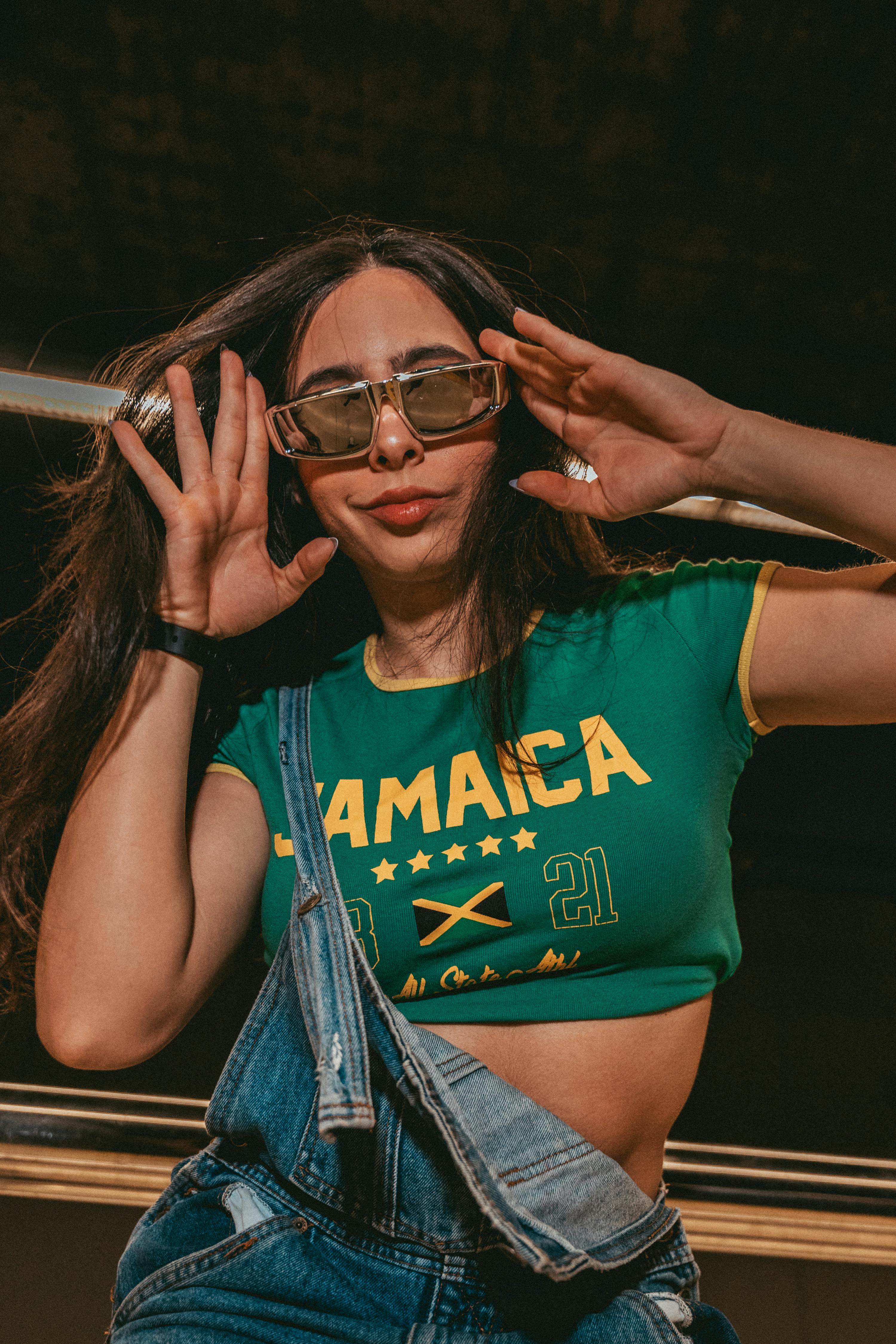 Playful Young Woman in Jamaica Crop Top and Overalls