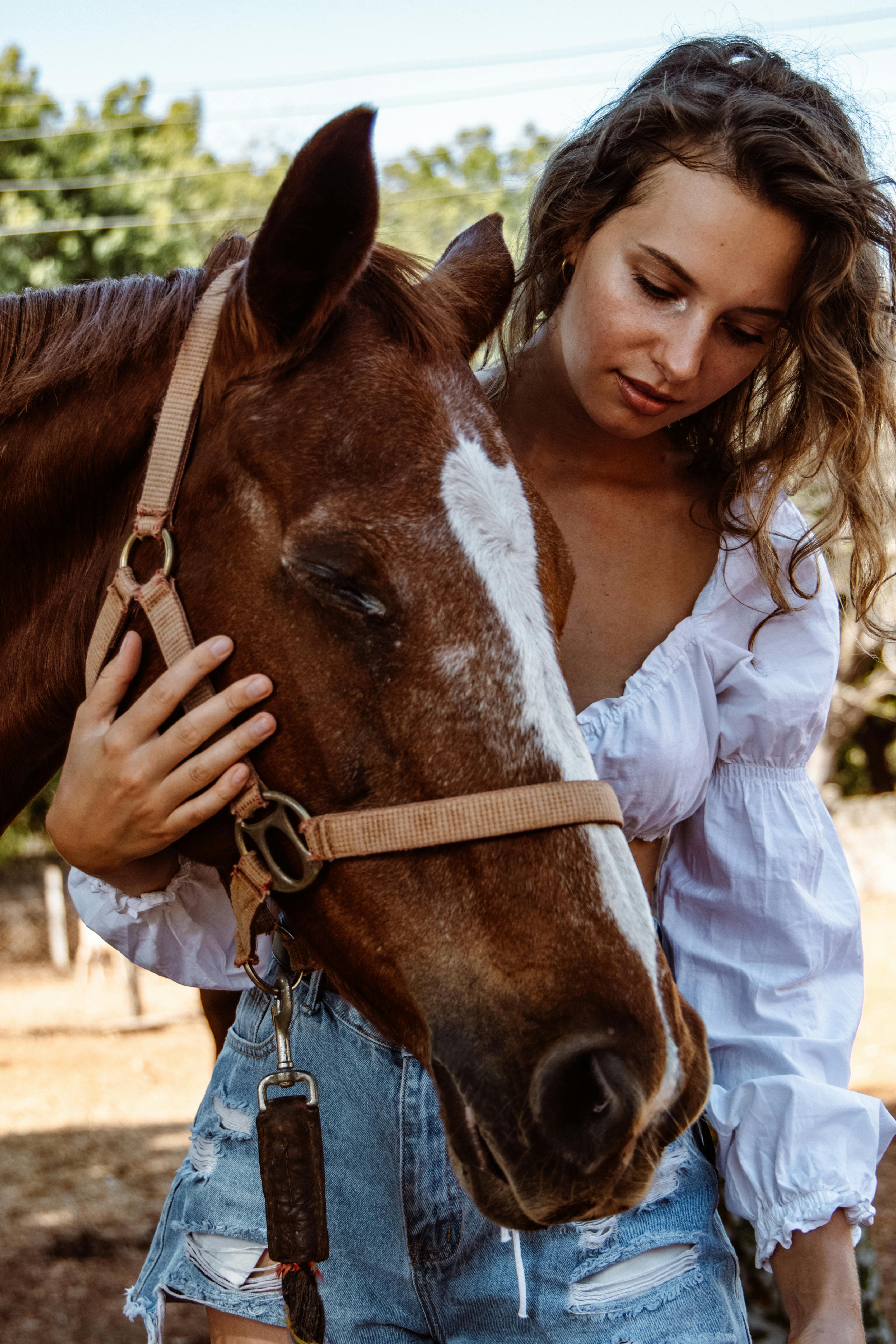Young Woman Embracing Brown Horse Outdoors