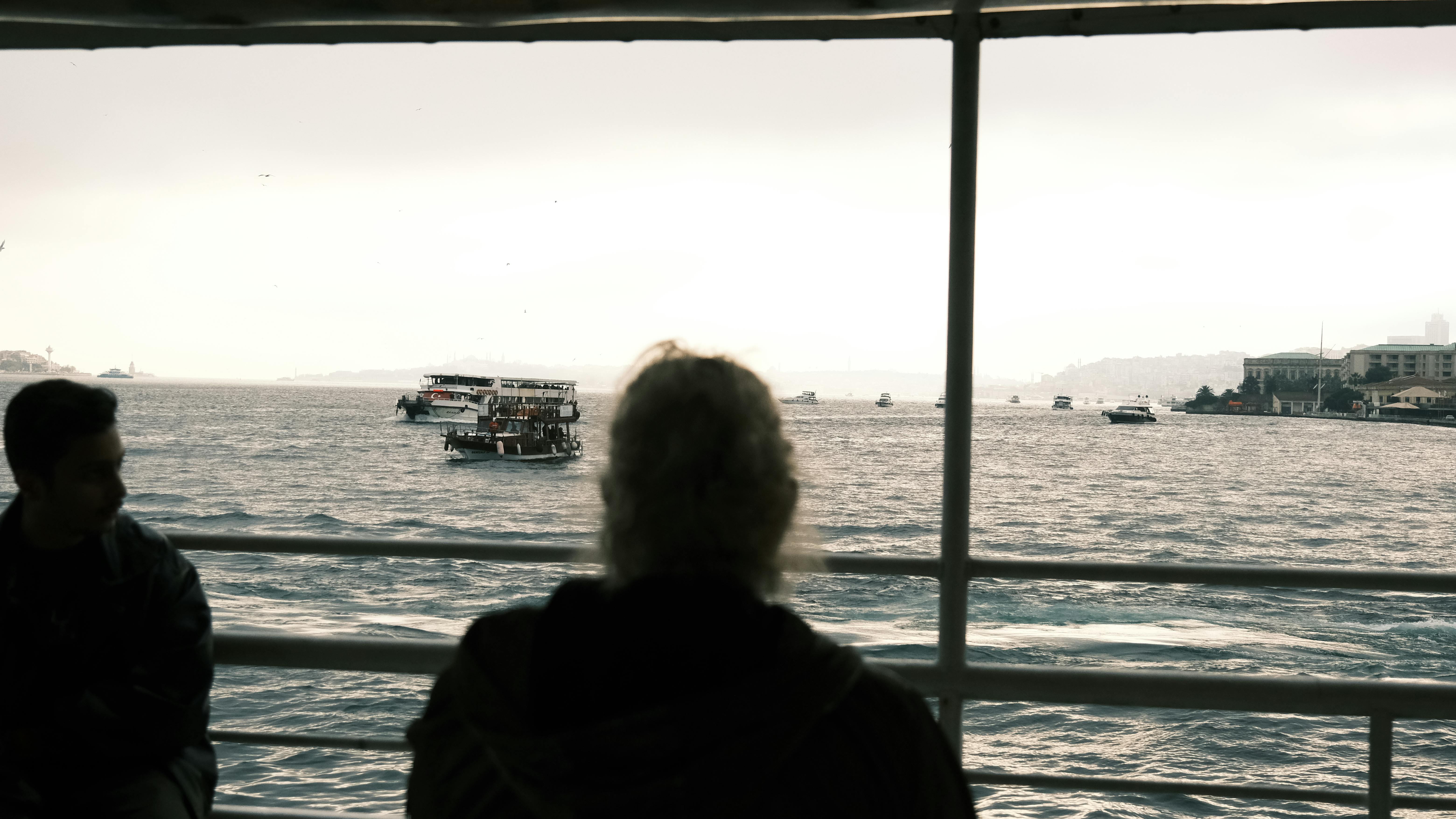 People on ferry crossing a busy strait