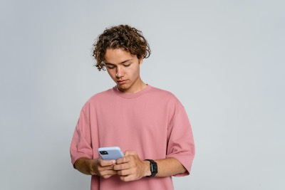 Young Man Texting on Smartphone with Focused Expression