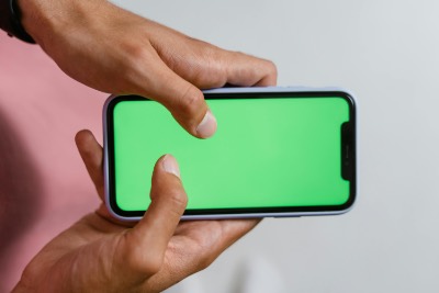 Hands Holding Smartphone with Green Screen Horizontally