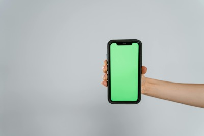 Hand Holding Smartphone with Green Screen Display