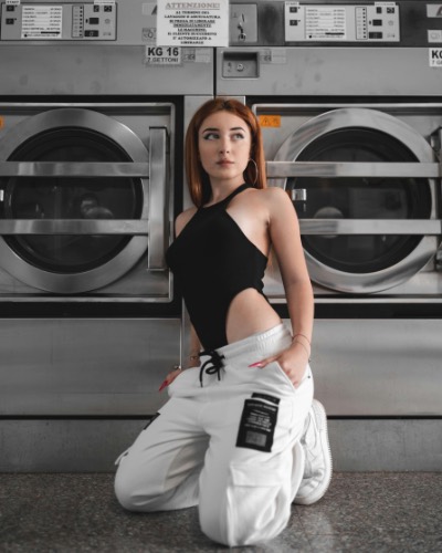 Stylish Young Woman Posing in Modern Laundromat