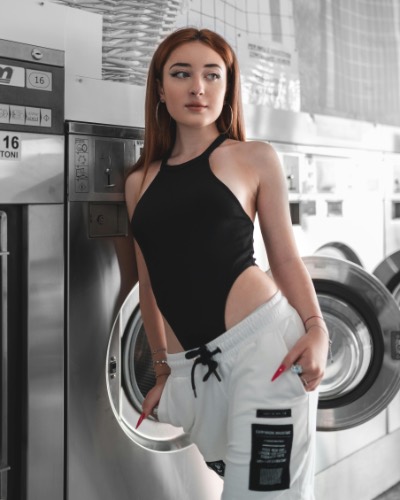 Young Woman Posing in Modern Laundromat