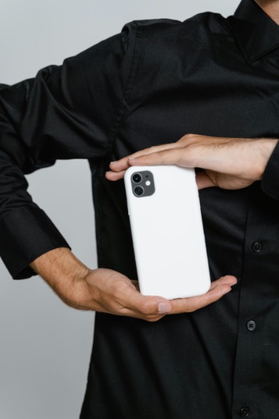 Person in black shirt holding white smartphone