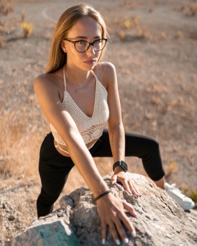 Young Woman in Glasses Posing on Rocky Terrain