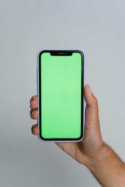 Hand Holding Smartphone with Green Screen Display