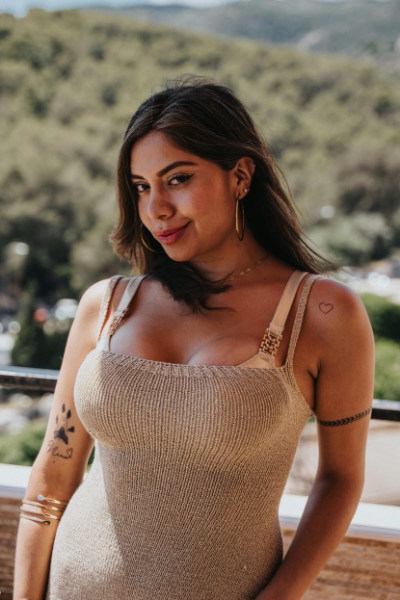 Smiling Woman Posing on Balcony with Green Hills